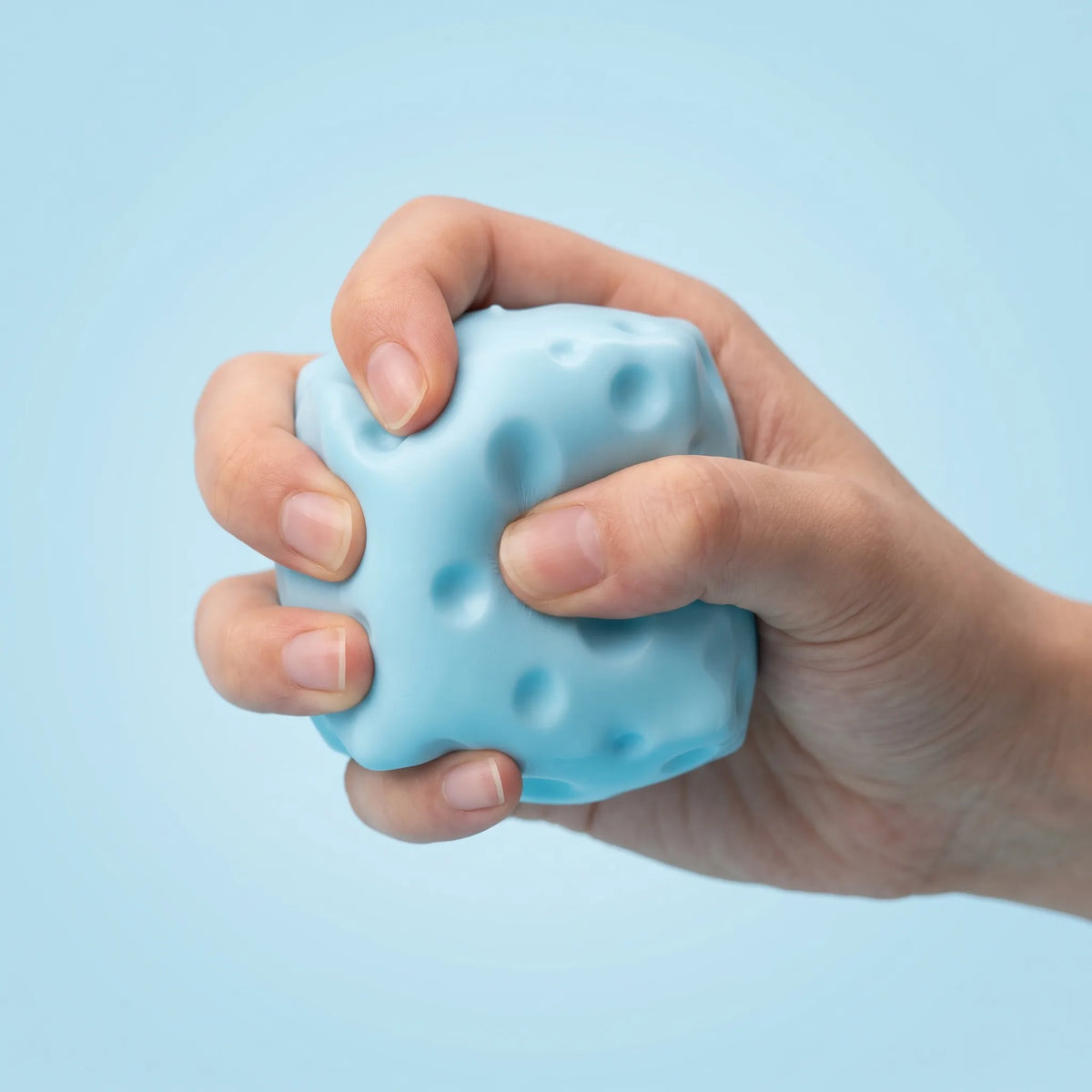 Hand squeezing the blue cheese squishy block to compress it evenly