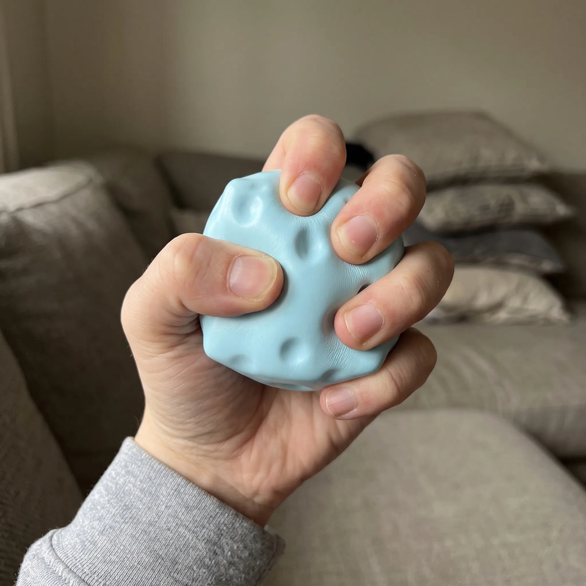 Adult hand pressing the blue cheese squishy block flat