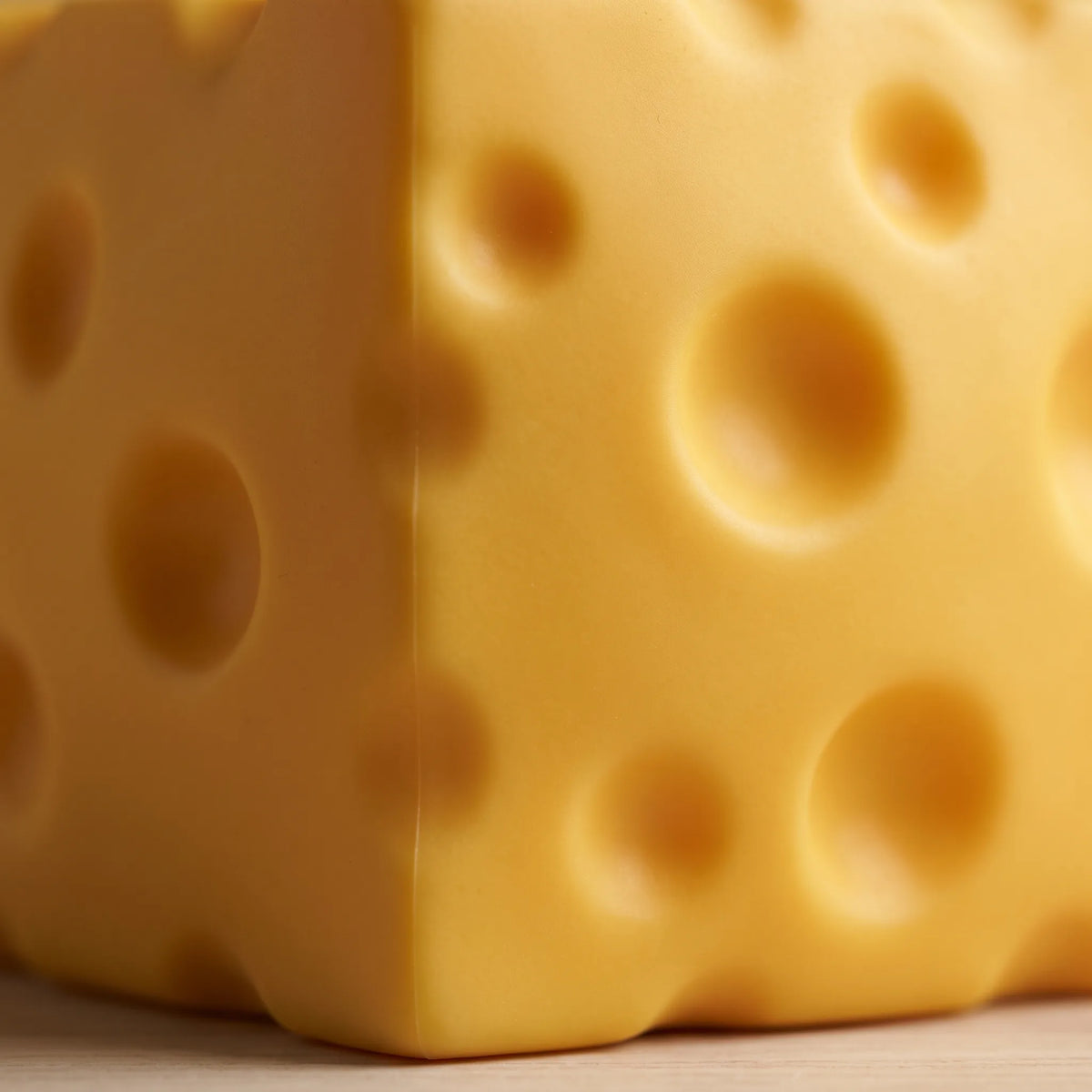 Close-up of the moulded holes and matte surface of the cheese squishy toy