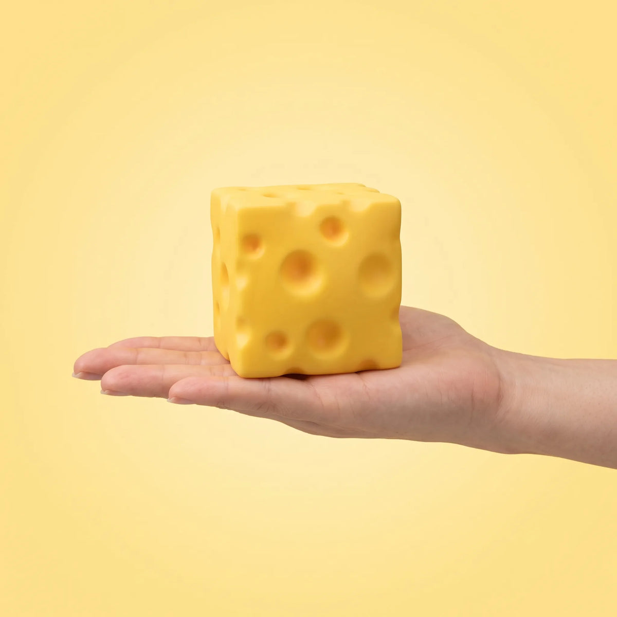 Cheese squishy toy held flat in an open hand to show its 5 to 6 cm size