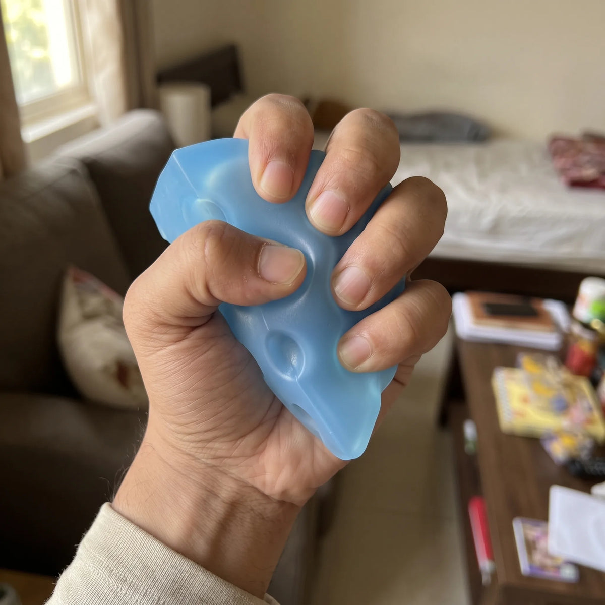 Adult hand pressing the ice blue cheese squishy wedge flat