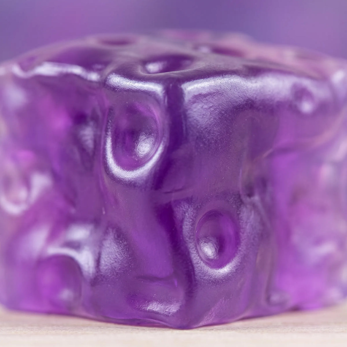 Macro view of the violet tint deepening toward the centre of the cheese squishy cube