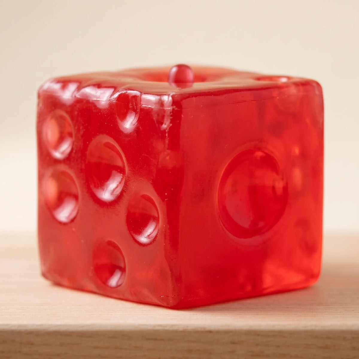 Macro view of the moulded holes glowing in the clear red cheese squishy cube