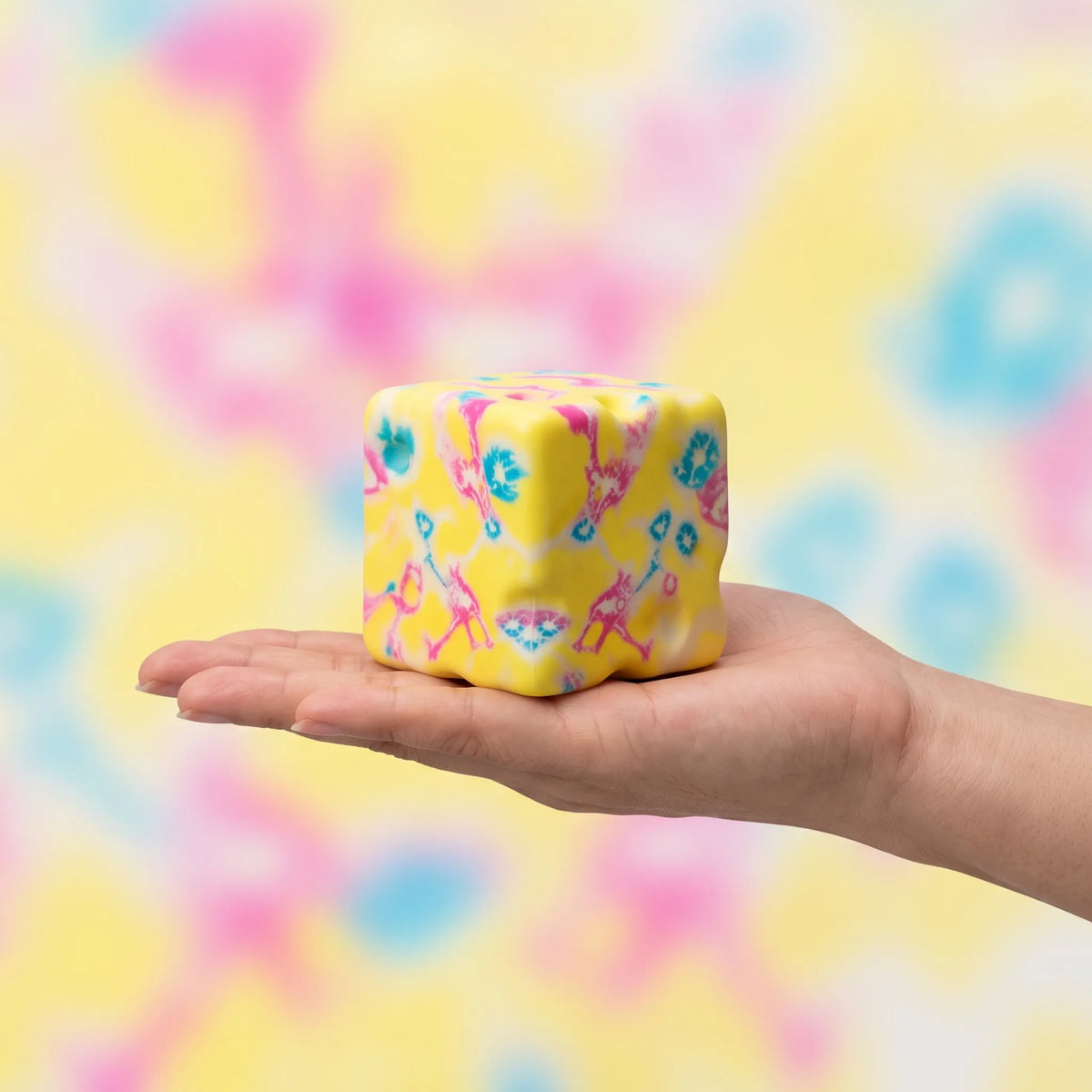 Flower yellow cheese squishy block held in a hand to show its 8 cm size