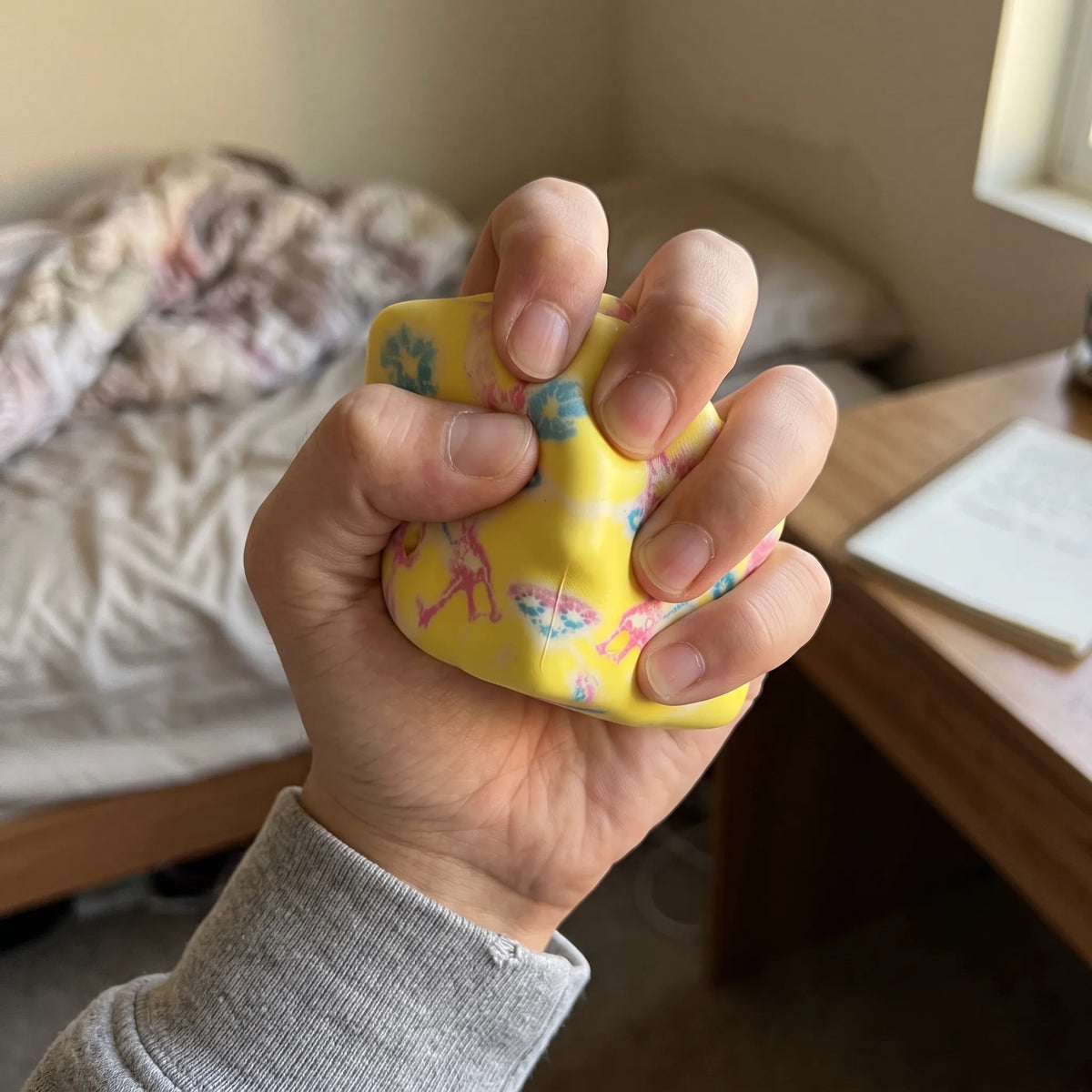 Hand pressing the flower yellow cheese squishy block flat