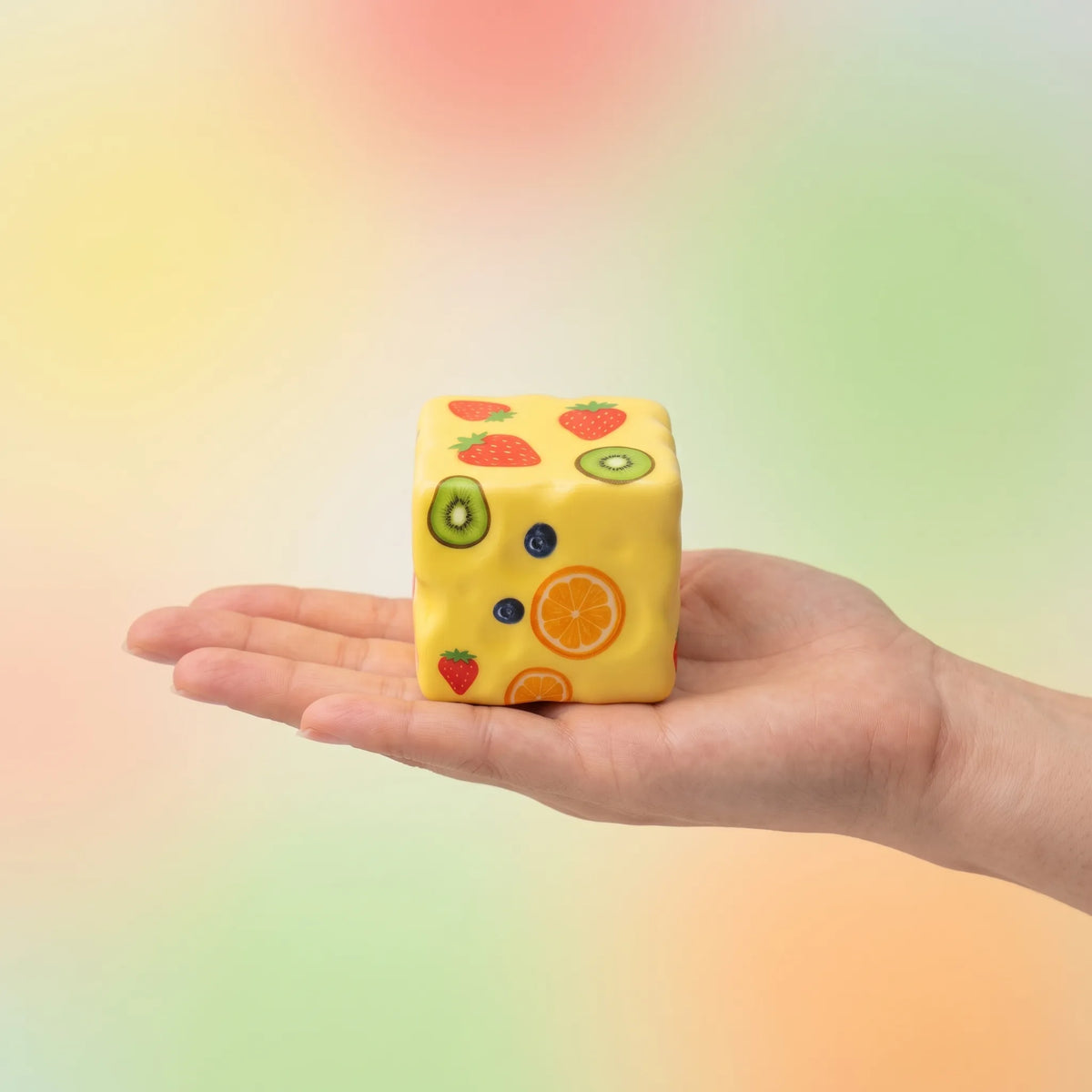 Fruit cheese squishy block held in an open hand to show its 8 cm size