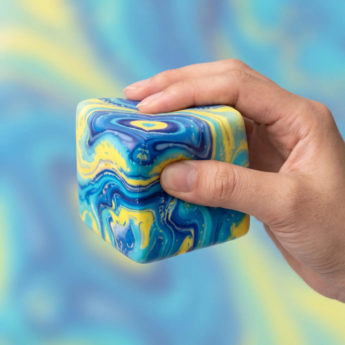 Hand squeezing the galaxy cheese squishy block