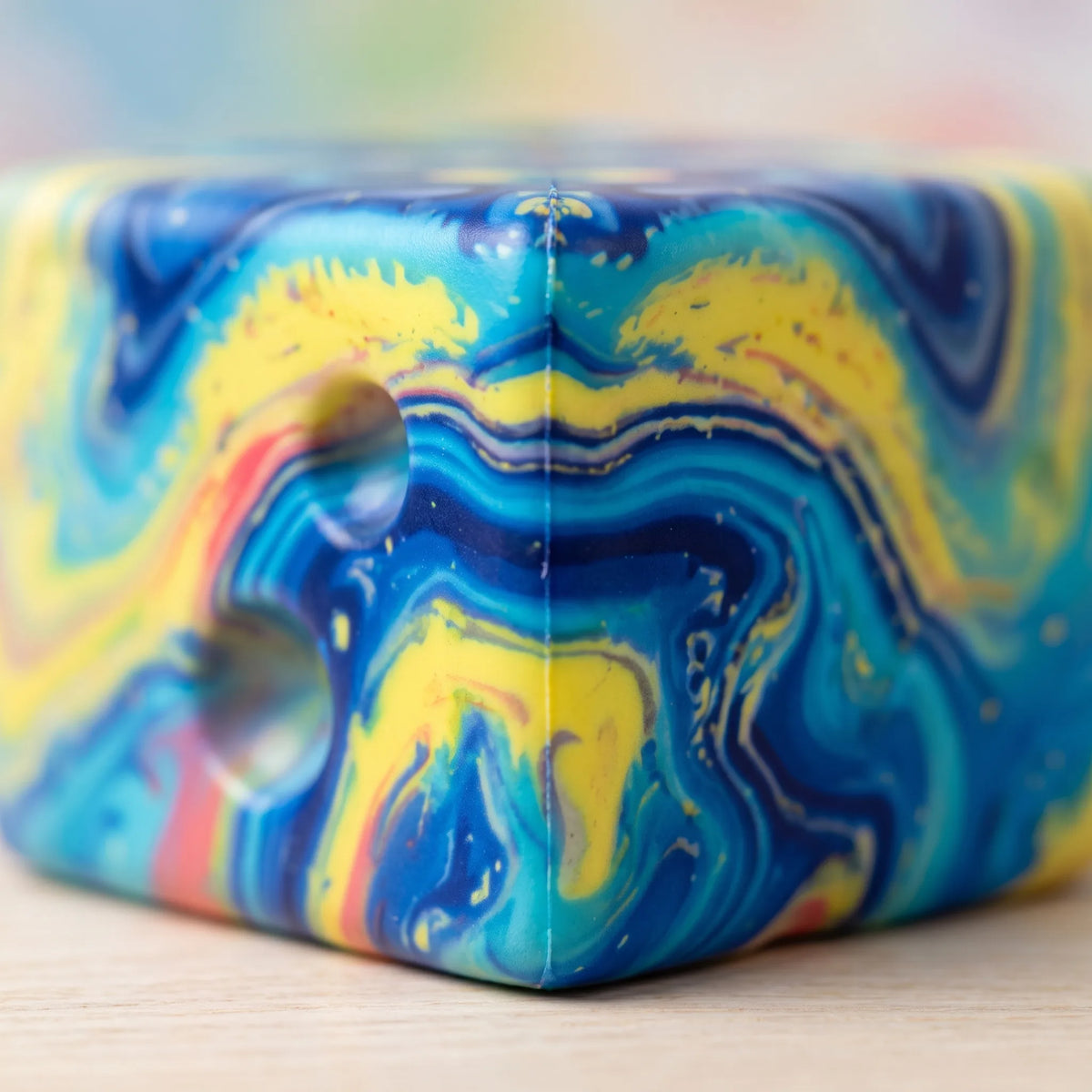 Close-up of the blue and gold swirl running over the holes of the galaxy cheese squishy block