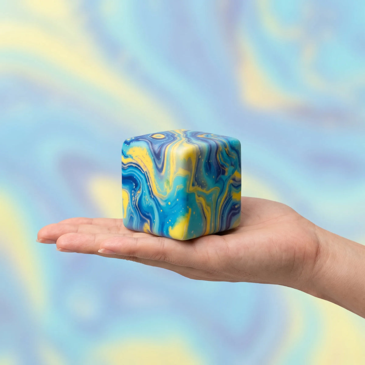 Galaxy cheese squishy block held in an open hand to show its 8 cm size