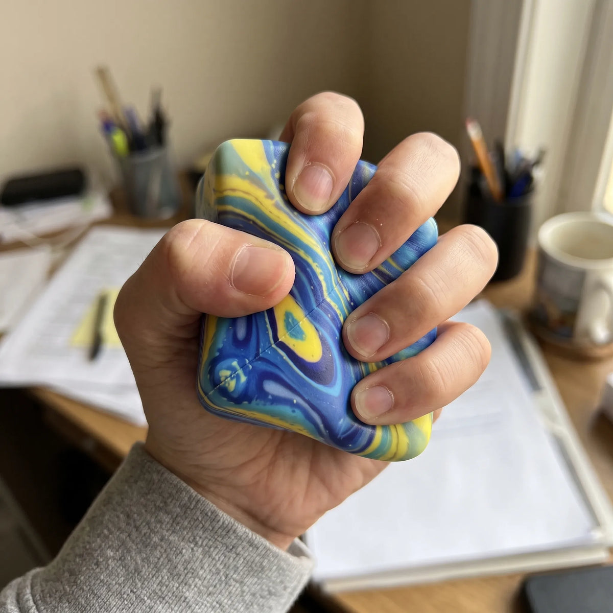 Adult hand pressing the galaxy cheese squishy block flat