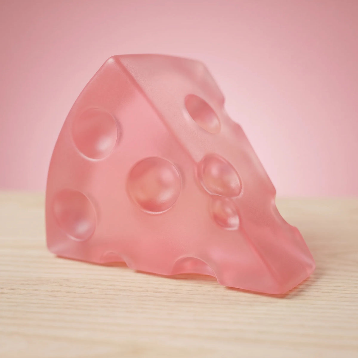 Close-up of the soft pink tint and open holes of the cheese squishy wedge