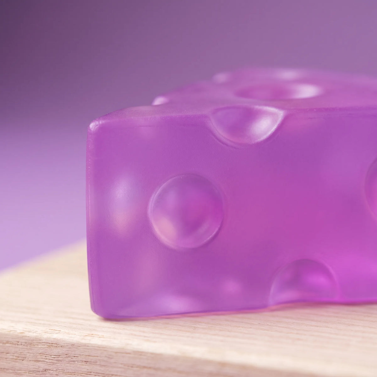 Macro view of the violet tint running through the body of the purple cheese squishy wedge