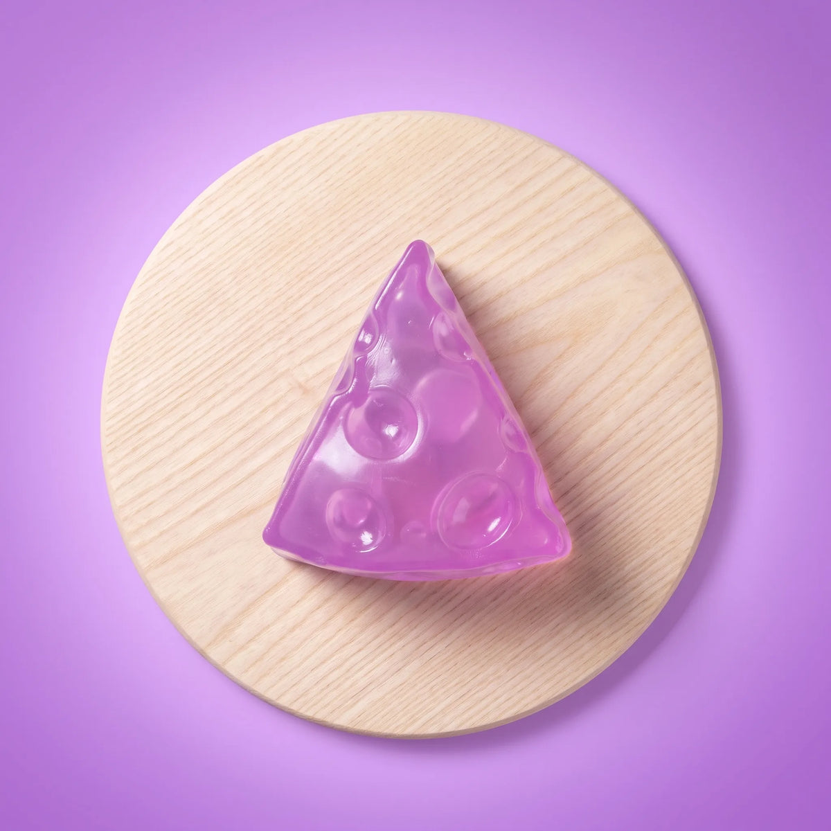 Translucent purple cheese squishy wedge photographed against a plain backdrop