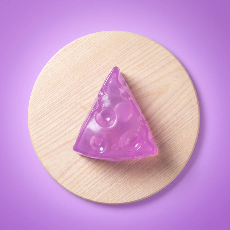 Translucent purple cheese squishy wedge photographed against a plain backdrop