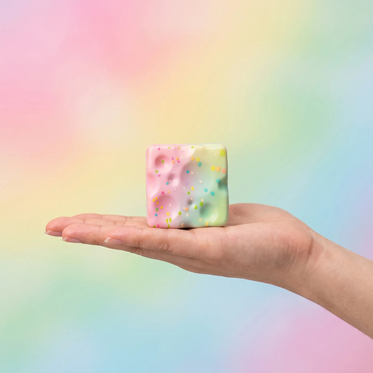 Sweet style cheese squishy block held in one hand to show its size