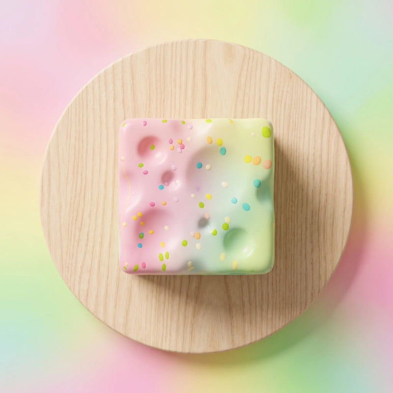 Pastel pink cheese squishy block covered in a candy sprinkle print